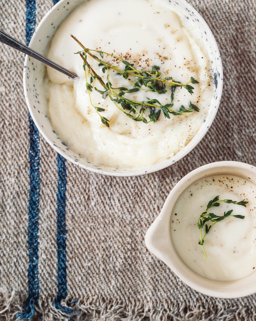 Bone Broth Gravy in a bowl next to a bowl of mashed potatoes